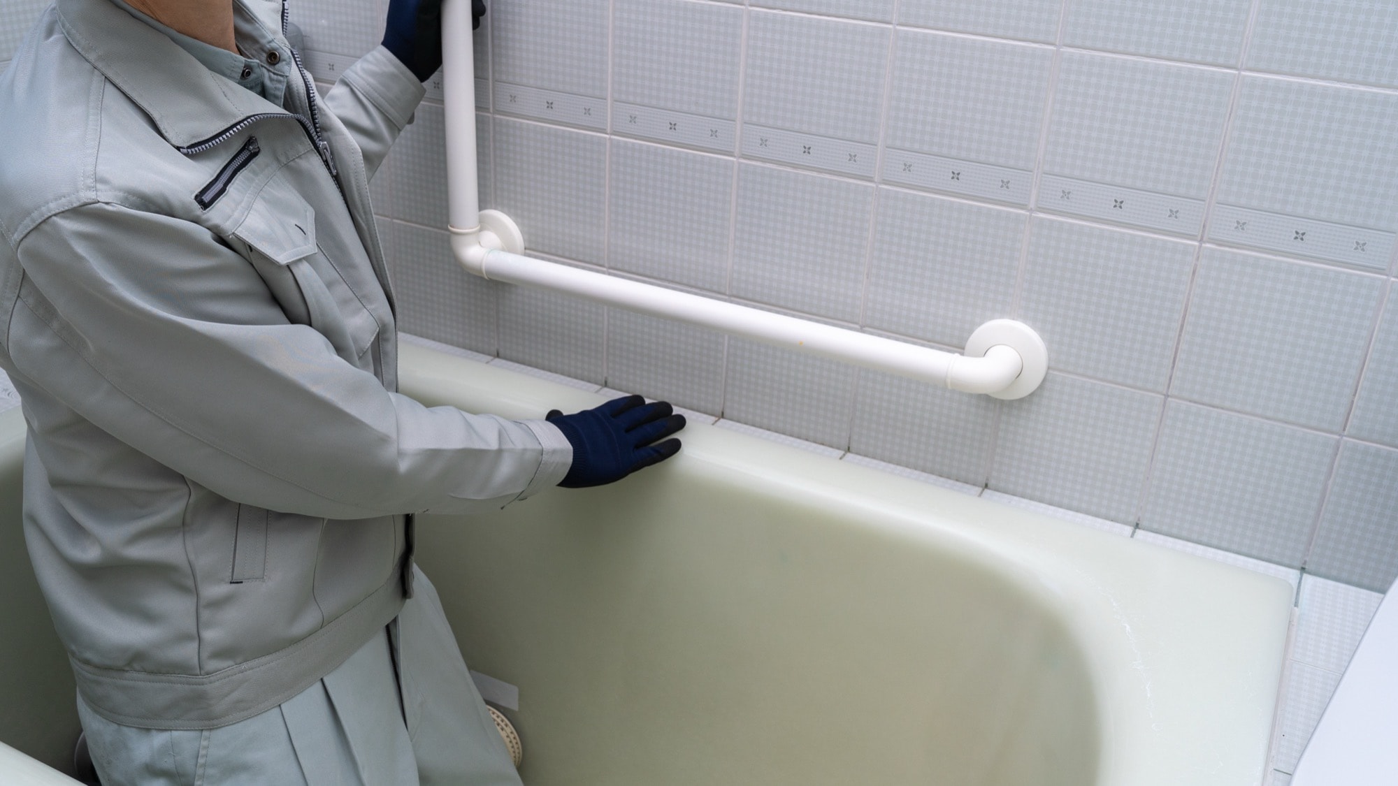 浴室用手すりを修理・点検する作業員